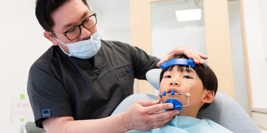 顎顔面矯正の装置を装着する子ども